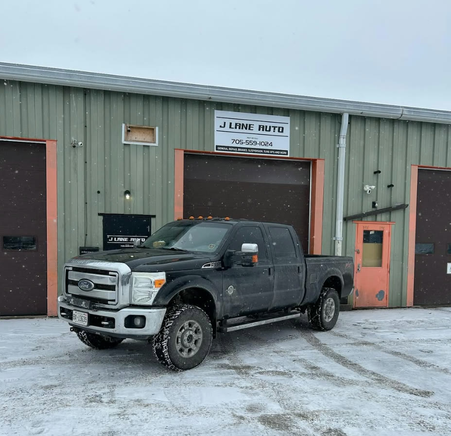 Black Ford F-350 work truck in the snow outside J Lane Auto