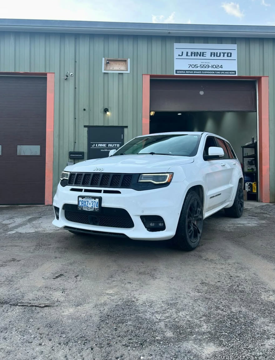 White Jeep Grand Cherokee SRT parked outside the J Lane Auto bay door