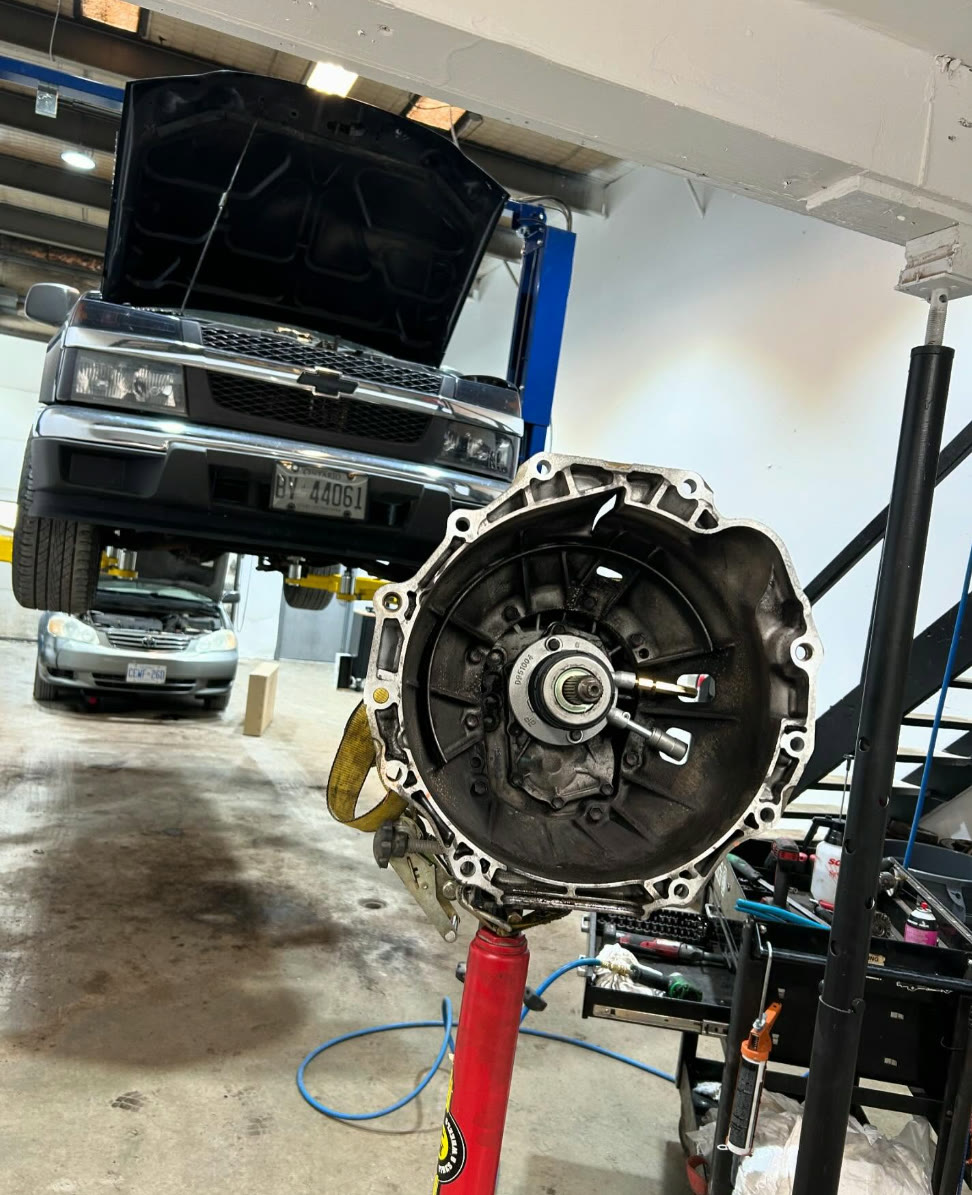 Transmission on a jack in front of a Chevrolet truck on the hoist